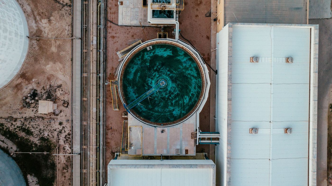 Aerial view of a circular water tank and plant buildings at an industrial site in Libya