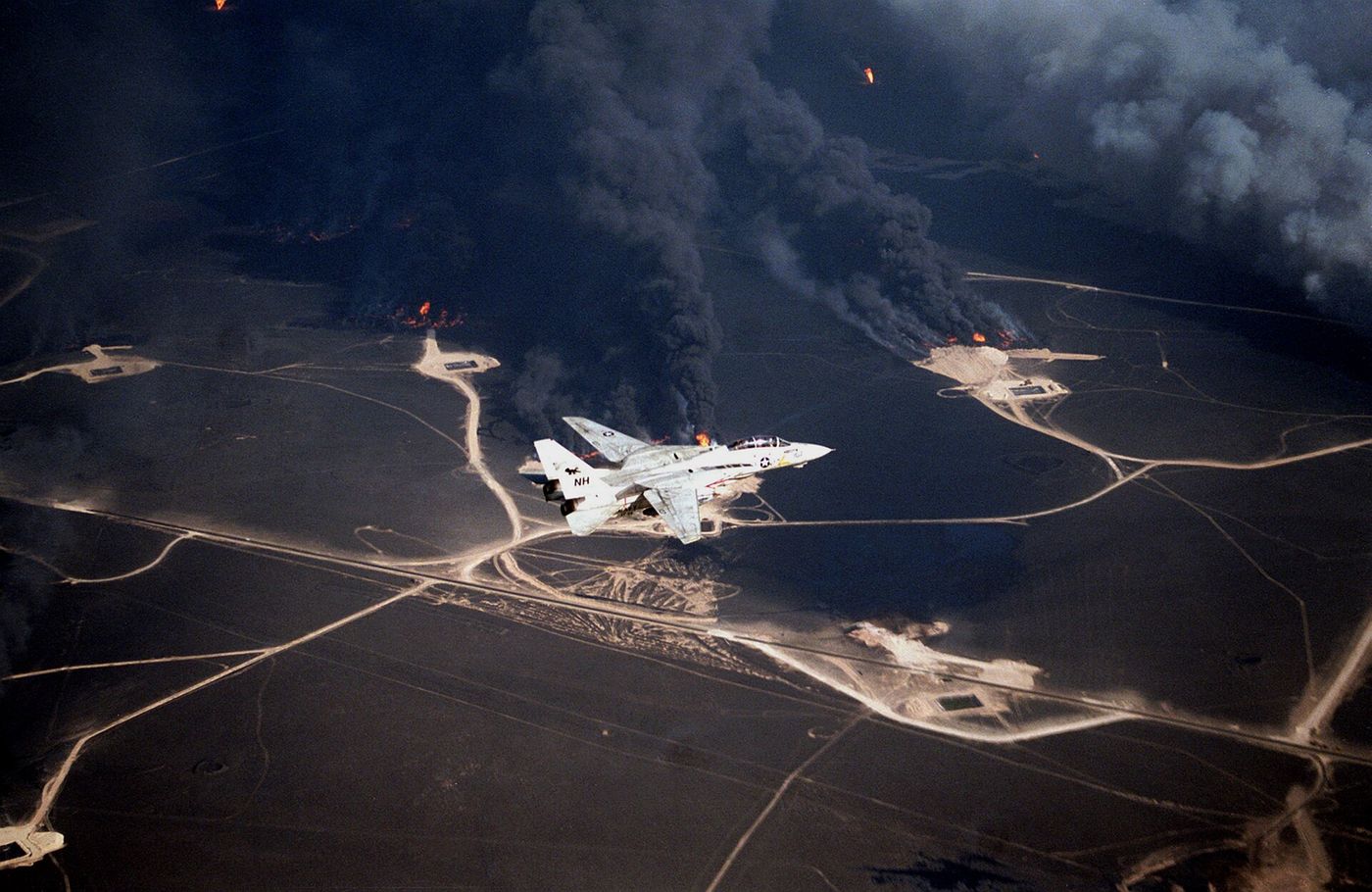A U.S. Navy F-14A flying over burning Kuwaiti oil wells during the 1991 Gulf war